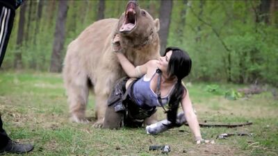UNA CHICA GUAPA POSA CON UN OSO PARA UN COSPLAY DE LARA CROFT