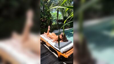 Liya Silver toma sol nua à beira da piscina