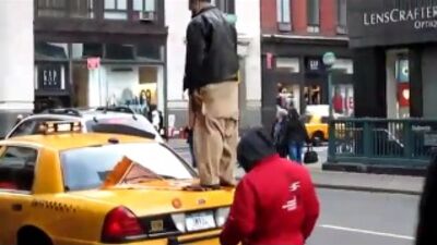 Ein Taxifahrer betet auf dem Kofferraum