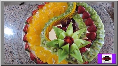 Um belo arranjo de frutas. Decoração para a mesa festiva. Como cortar frutas. Escultura em frutas