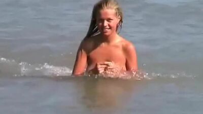 Une blonde sexy nue sur la plage