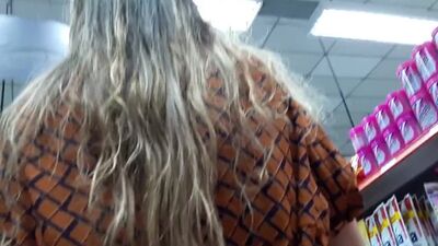 Voyeur : jupe relevée d'une blonde au naturel en collants