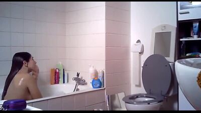 Una chica se está bañando en la bañera