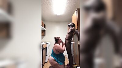 Uma mulher gorda branca chupa um grande pénis negro