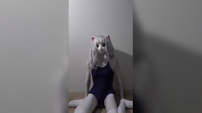 Una simpática gata Kigurumi en bañador se corre con una varita mágica