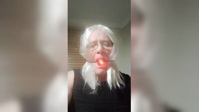 Daisy com uma bola na boca para um gay que tira selfies