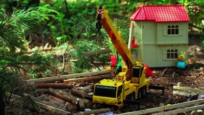 Dessin animé sur les petits véhicules : un tracteur avec une remorque, une pelleteuse et une grue mobile construisent une maison. ManKiMult